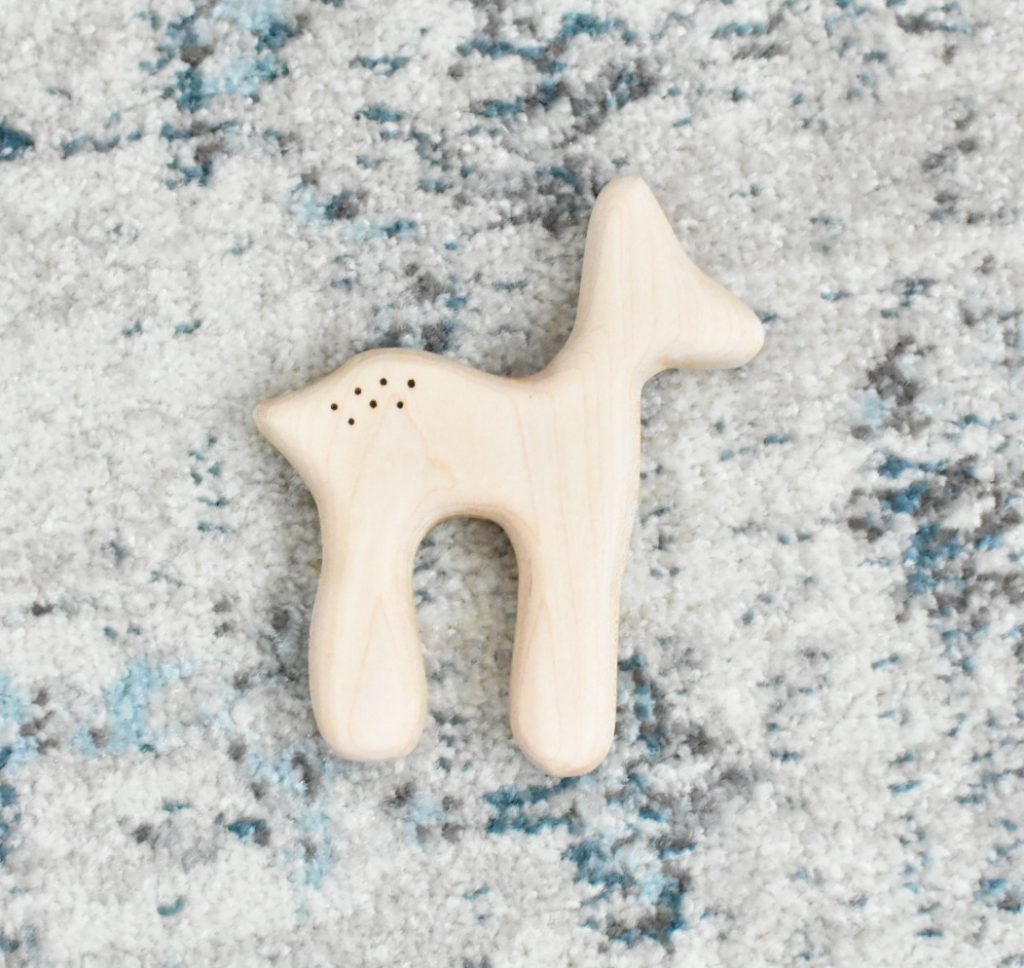 The image shows a natural wooden deer teether.